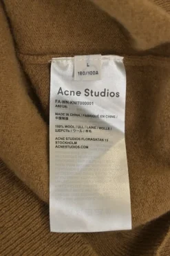 Camel wool button-front cardigan featuring signature leather face logo chest patch