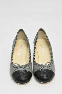 Charcoal leather round-toe ruffle edge cap toe pumps with topstitched Coco Mark detail