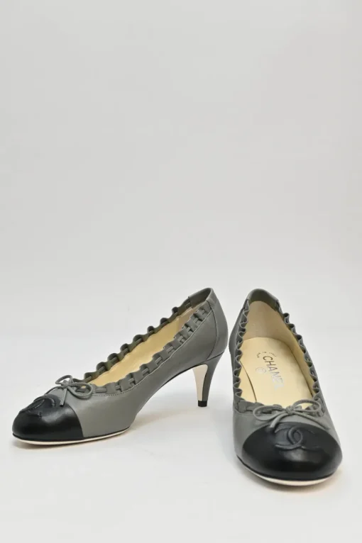 Charcoal leather round-toe ruffle edge cap toe pumps with topstitched Coco Mark detail