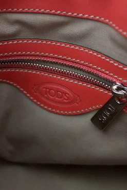 Coral leather satchel bag with visible top stitch and shoulder strap.