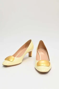 Cream patent leather almond-toe court pumps with signature pebble vamp buckle