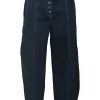 Dark indigo cotton denim pull-on high-rise bow leg jeans with exposed button fly fastening
