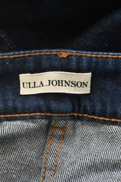Dark indigo cotton denim pull-on high-rise bow leg jeans with exposed button fly fastening