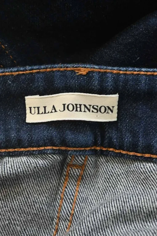 Dark indigo cotton denim pull-on high-rise bow leg jeans with exposed button fly fastening