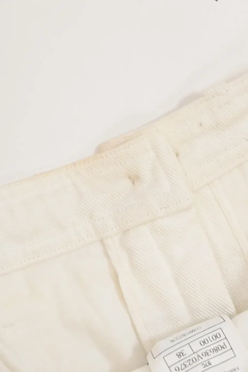 Ecru cotton denim pull-on high-rise skinny jeans with Coco Mark shank button appliqué along cuffs