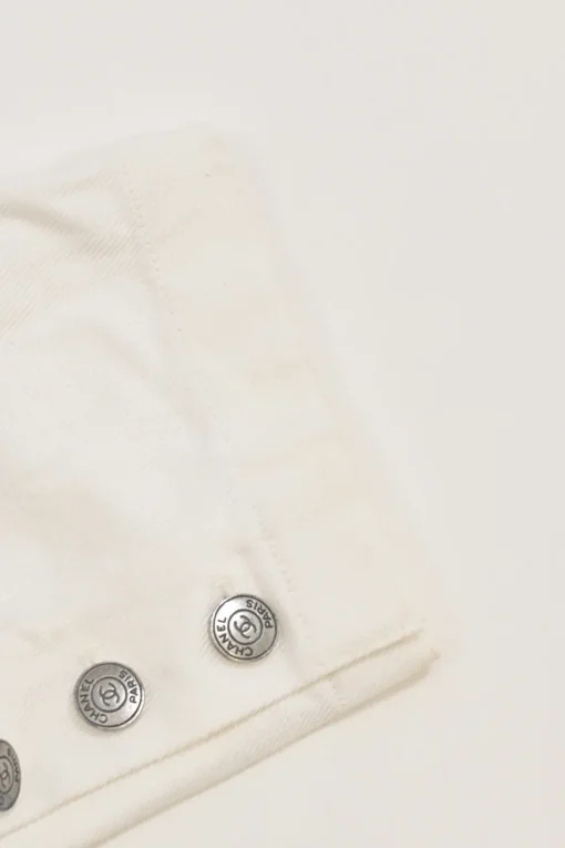 Ecru cotton denim pull-on high-rise skinny jeans with Coco Mark shank button appliqué along cuffs