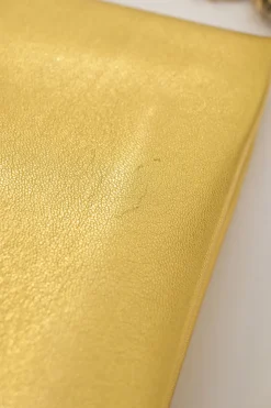 Gold foiled leather frog tassel clutch with gold-tone metallic hardware