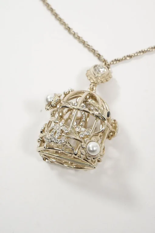 Gold metal with crystals and white resin pearls logo bird cage necklace