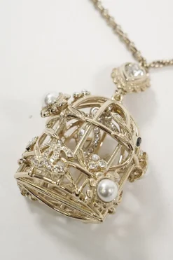 Gold metal with crystals and white resin pearls logo bird cage necklace