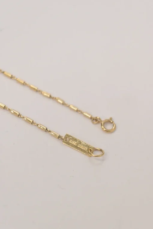 Gold-tone metal Zanzibar tube link necklace with horn pendant