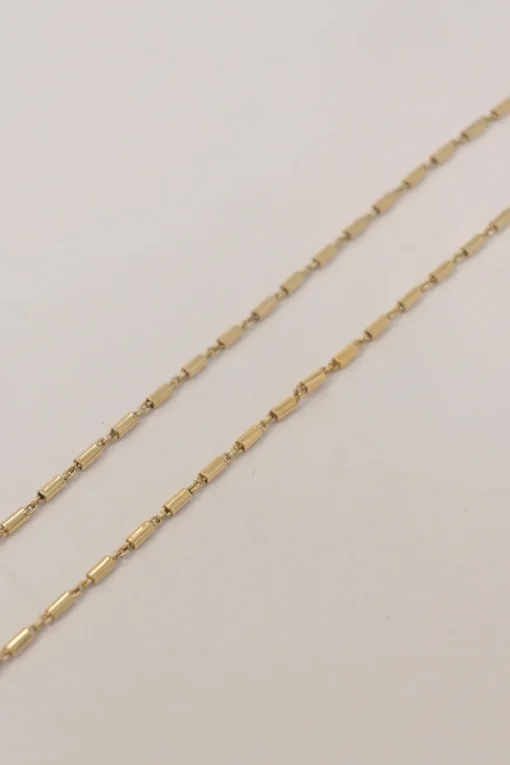 Gold-tone metal Zanzibar tube link necklace with horn pendant