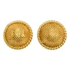 Gold-tone metallic clip-on dome earrings with braided edges