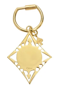 Gold-tone metallic stamped key ring featuring abstract motif