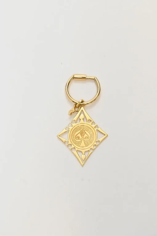 Gold-tone metallic stamped key ring featuring abstract motif