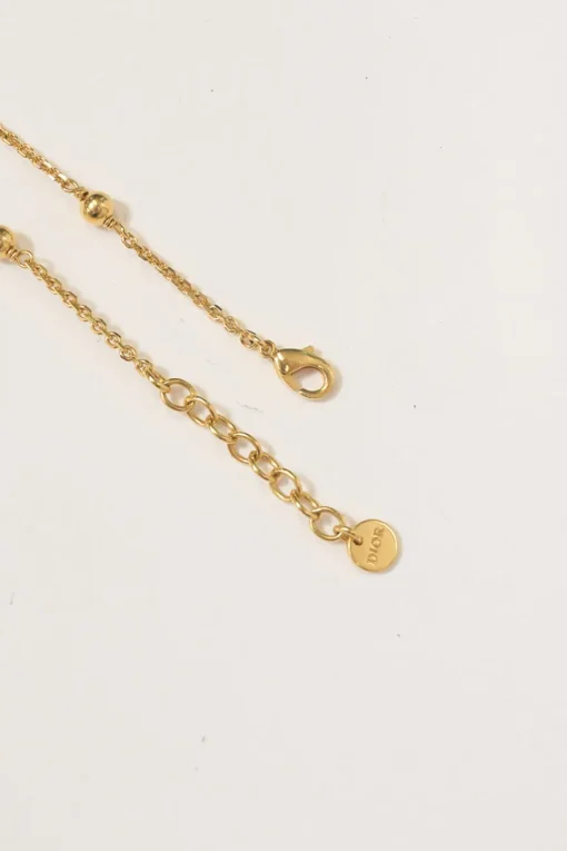 Gold-tone permabrass Petit CD charm bracelet with lobster clasp closure