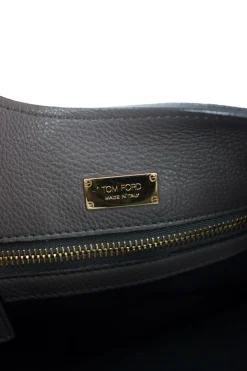 Grey leather handbag with detachable shoulder strap and large gold zipper detail