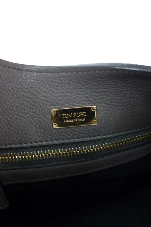 Grey leather handbag with detachable shoulder strap and large gold zipper detail