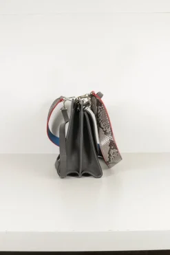 Grey pebbled leather bag with front flap, magnetic clasp and short top handle.