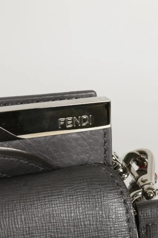 Grey pebbled leather bag with front flap, magnetic clasp and short top handle.