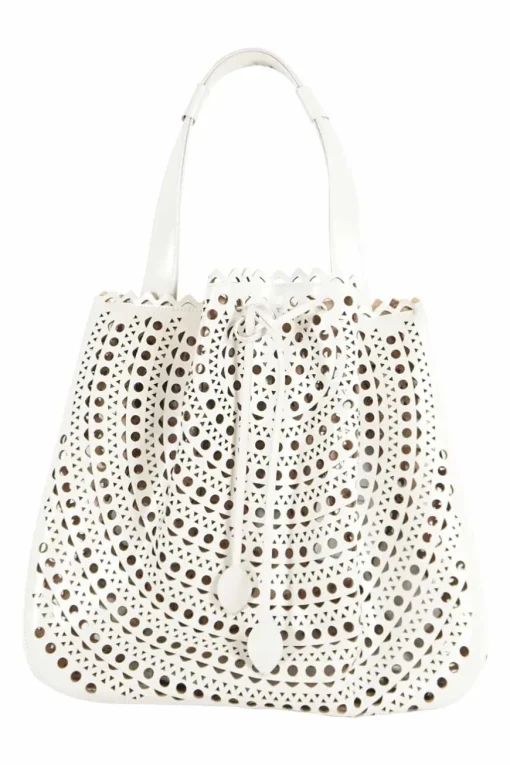 Grey perforated leather top handle bag. Drawstring closure. Bag comes with detachable leather zip pouch