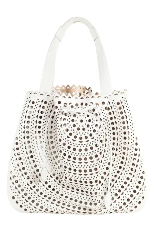 Grey perforated leather top handle bag. Drawstring closure. Bag comes with detachable leather zip pouch