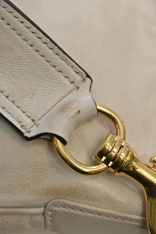 Ivory aged leather snap hook shoulder bag with gold-tone metallic hardware