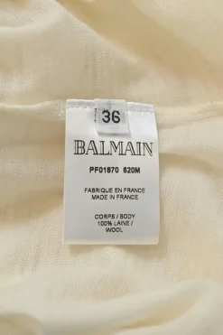 Ivory semi-sheer wool interlock jersey funnel collar pullover long sleeve top with coat of arms shoulder line shank button appliqué