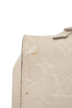 Louis Vuitton Empreinte monogram embossed calf leather bag in cream colour with zip closure. Rectangular shape with 2 shoulder straps. Bag has one external zipped pocket. Interior is fabric lined, with two side pockets, and a third on front panel. Gold toned hardware.