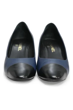 Navy and black contrast leather almond-toe pumps with patterned gold-tone metal heels and black Coco logo on ankle counter