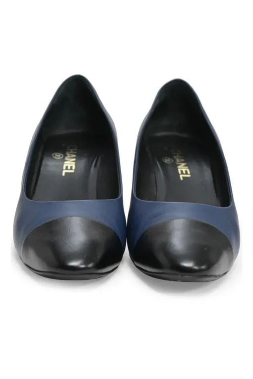 Navy and black contrast leather almond-toe pumps with patterned gold-tone metal heels and black Coco logo on ankle counter