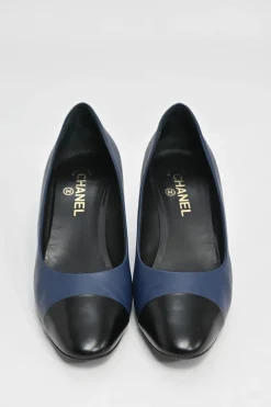 Navy and black contrast leather almond-toe pumps with patterned gold-tone metal heels and black Coco logo on ankle counter
