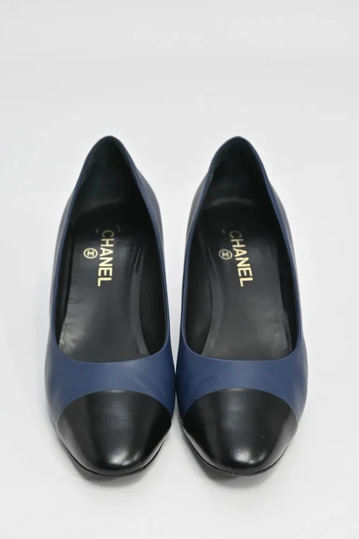 Navy and black contrast leather almond-toe pumps with patterned gold-tone metal heels and black Coco logo on ankle counter