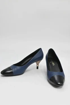 Navy and black contrast leather almond-toe pumps with patterned gold-tone metal heels and black Coco logo on ankle counter