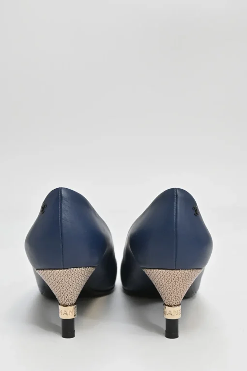 Navy and black contrast leather almond-toe pumps with patterned gold-tone metal heels and black Coco logo on ankle counter