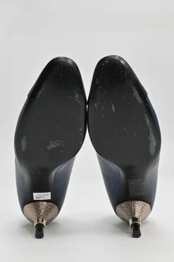 Navy and black contrast leather almond-toe pumps with patterned gold-tone metal heels and black Coco logo on ankle counter