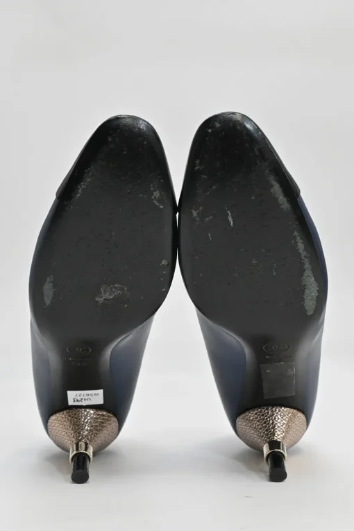 Navy and black contrast leather almond-toe pumps with patterned gold-tone metal heels and black Coco logo on ankle counter