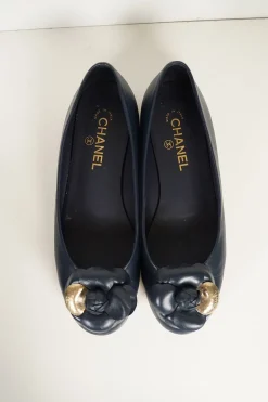 Navy calfskin camellia ballerinas with contrast metallic petal and brand-signature Coco Mark plaque