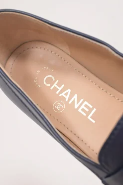 Navy leather penny-style slip-on loafers featuring silver-finish metallic Coco Mark plaque