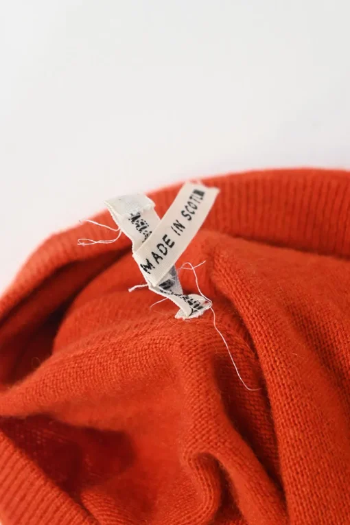 Orange cashmere jersey knit two-piece set with sleeveless turtleneck and crewneck button-front cardigan