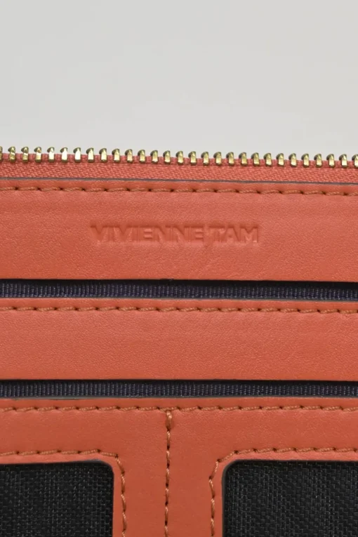 Orange grained printed leather turnlock flap envelope clutch featuring painterly floral motif