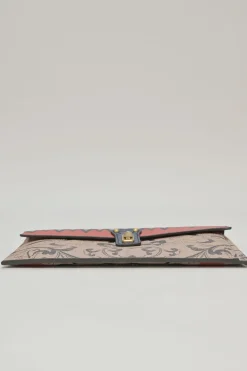 Orange grained printed leather turnlock flap envelope clutch featuring painterly floral motif