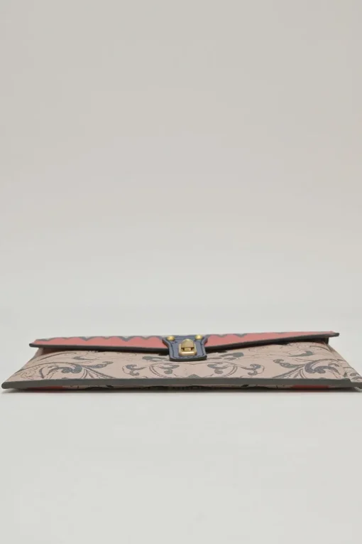 Orange grained printed leather turnlock flap envelope clutch featuring painterly floral motif
