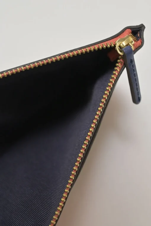 Orange grained printed leather turnlock flap envelope clutch featuring painterly floral motif