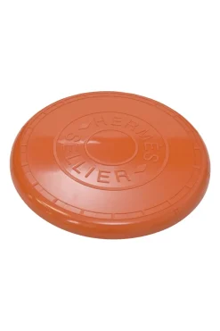 Orange plastic Wouf flying disc featuring 'Hermès Sellier Paris' embossed detail