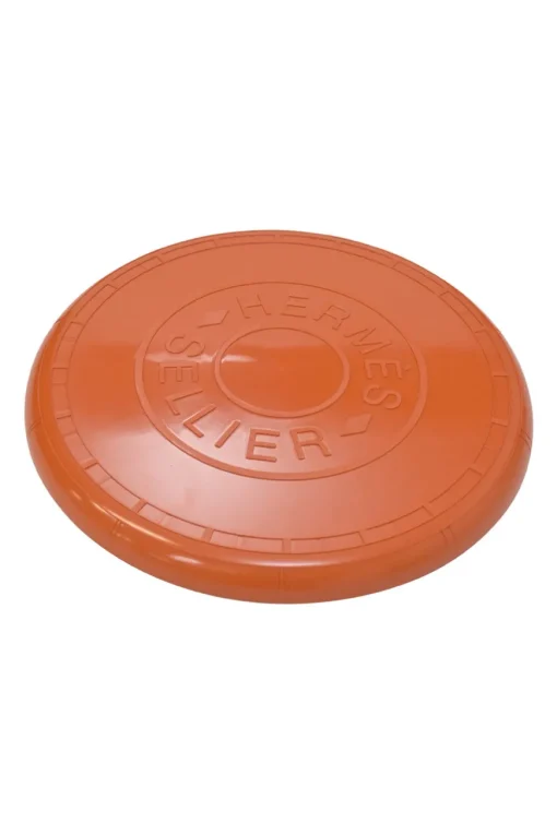 Orange plastic Wouf flying disc featuring 'Hermès Sellier Paris' embossed detail