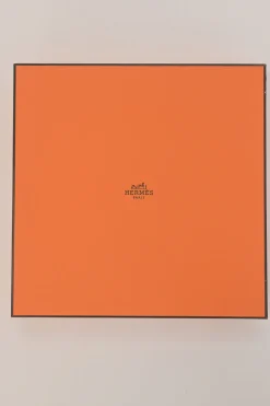 Orange plastic Wouf flying disc featuring 'Hermès Sellier Paris' embossed detail