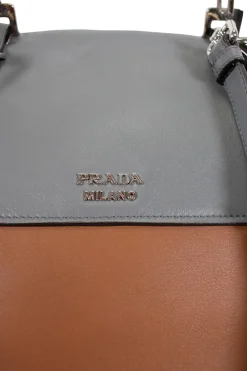 Prada single top handle bag in camel with contrasting grey flap.