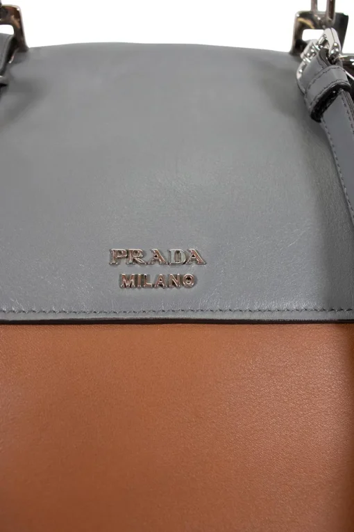 Prada single top handle bag in camel with contrasting grey flap.