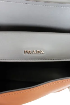 Prada single top handle bag in camel with contrasting grey flap.