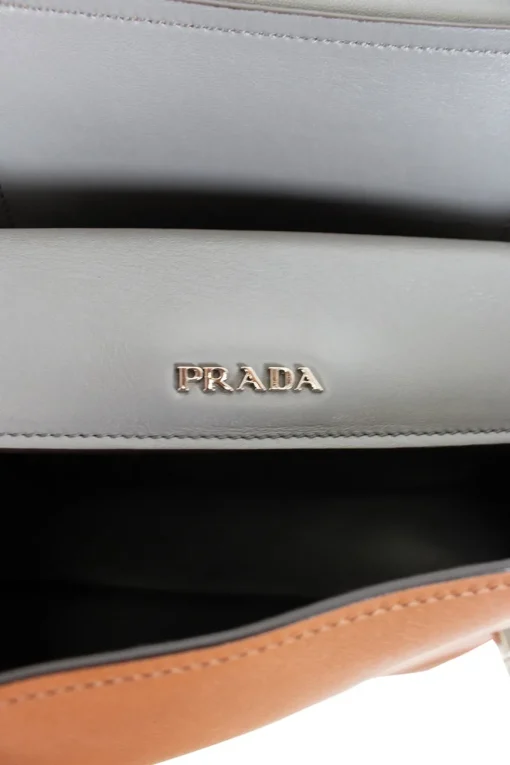 Prada single top handle bag in camel with contrasting grey flap.